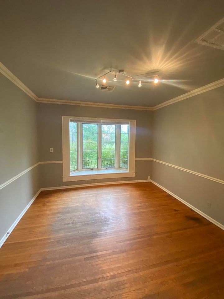a empty room with a window and wooden floors