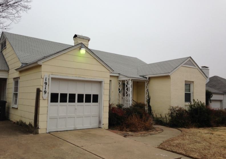 a white house with a garage and a light on it
