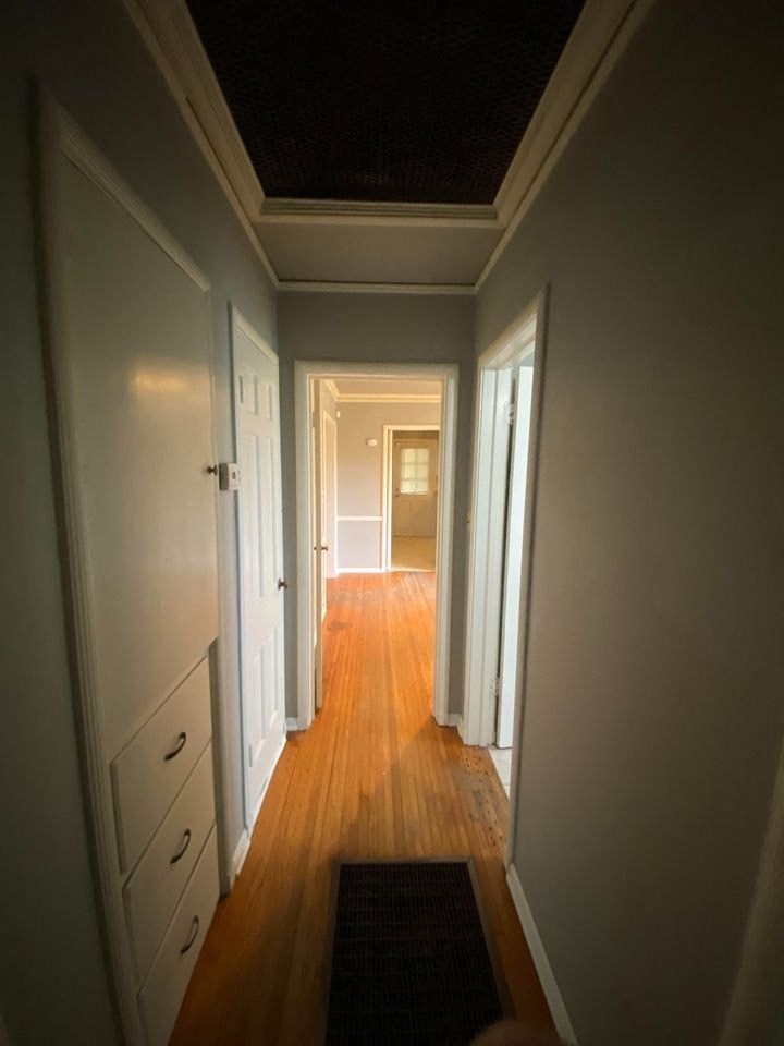 a hallway with a wood floor and white walls and doors