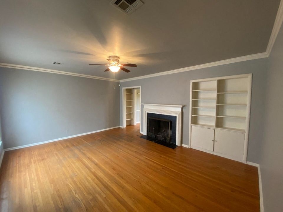 a living room with a fireplace and a ceiling fan