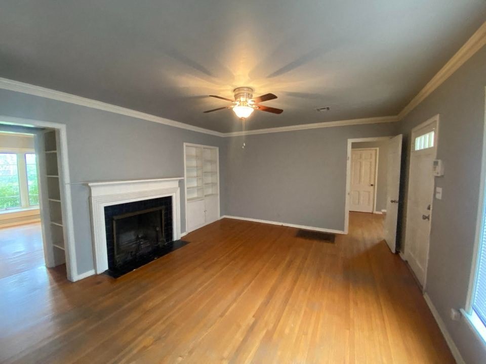 a living room with a fireplace and a ceiling fan