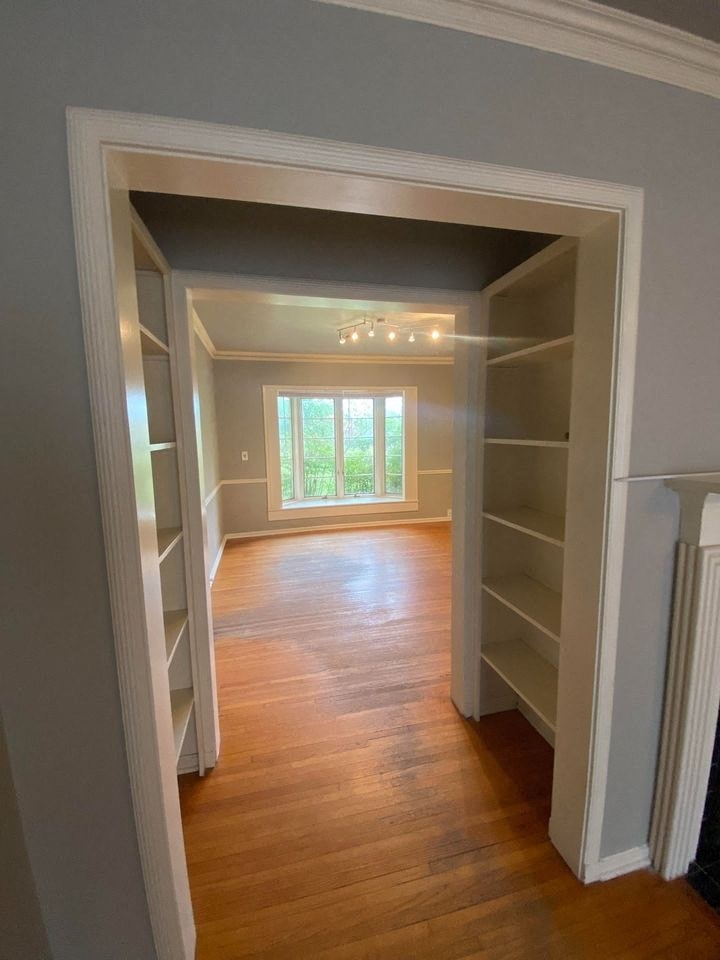 a empty room with shelves and a window