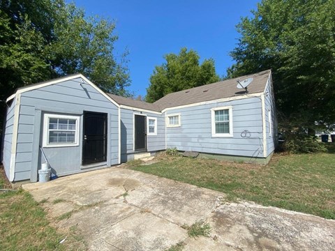 a blue house with a yard and a driveway
