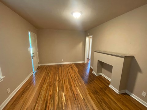 a living room with wood floors and a fireplace