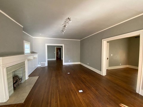 a living room with a fireplace and wooden floors