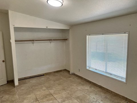 an empty room with a large window and a tile floor