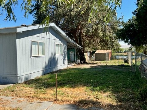 a blue house with a yard and a fence