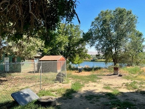 a backyard with a fence and a body of water