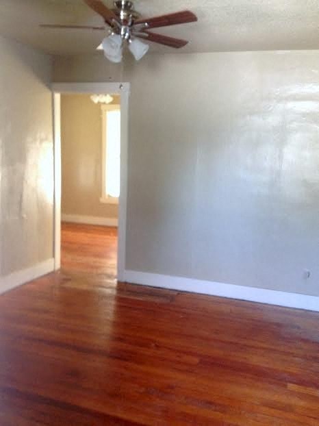 a living room with a wood floor and a ceiling fan