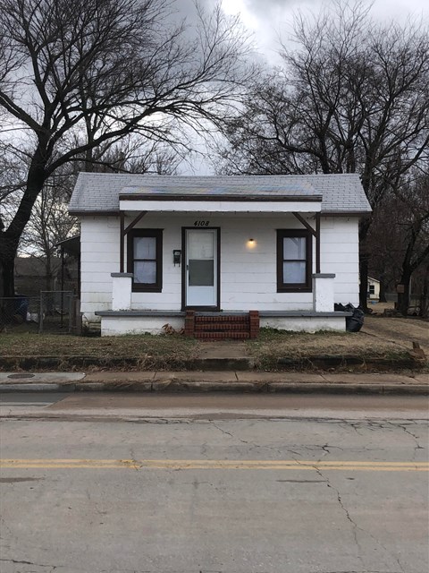 a small white house on the side of the street