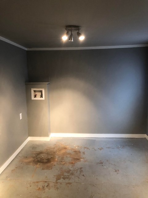 an empty room with a blue wall and a white floor and a ceiling fan