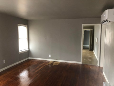 a living room with a hard wood floor and grey walls