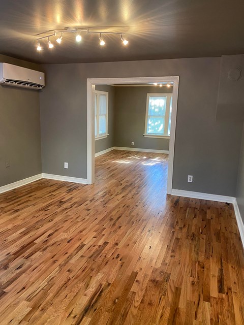 a living room with a hard wood floor and gray walls
