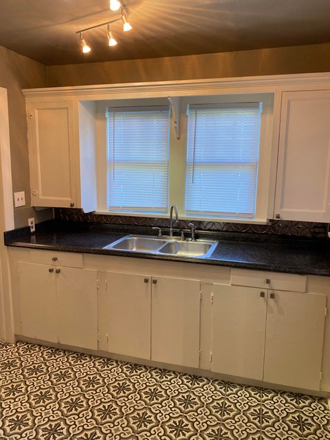 a kitchen with white cabinets and a sink