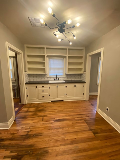 a kitchen with white cabinets and a sink and a window