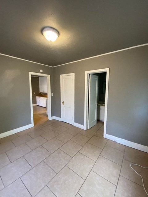 an empty living room with gray walls and a tile floor