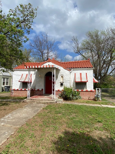 A white house with a red roof and a red door.