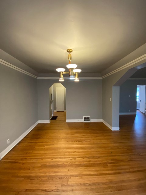 an empty living room with wood floors and grey walls