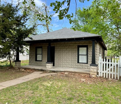 a small white house with a white picket fence