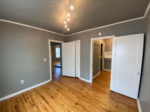 A room with wooden floors and white doors.
