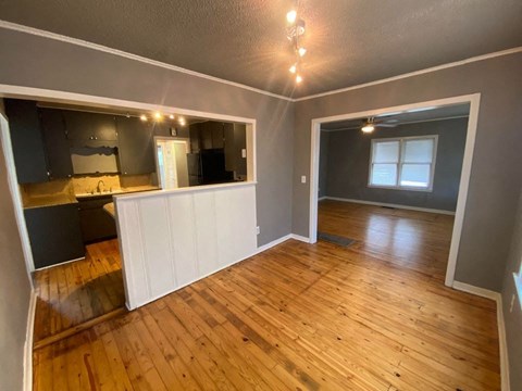 A room with wooden flooring and a large mirror on the wall.