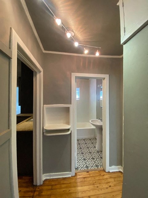 A bathroom with a toilet, sink, and a patterned floor.