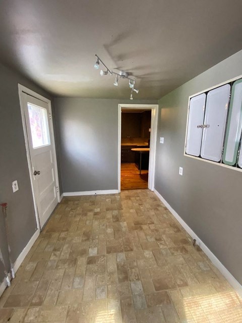 A room with a tiled floor and a doorway leading to another room.