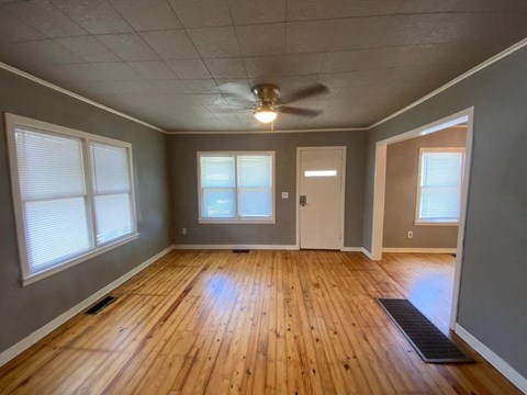 A room with wooden floors and a ceiling fan.