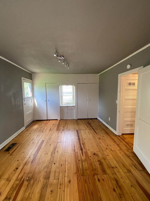 A room with wooden floors and white walls.