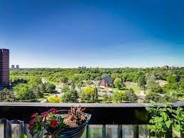 A balcony with a view of a green landscape and buildings in the distance.
