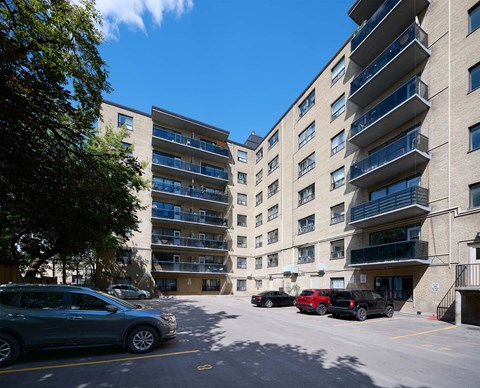 A parking lot with cars and apartment buildings.