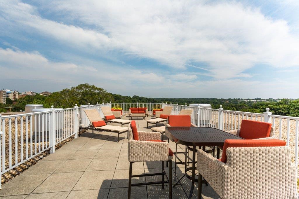 a patio with tables and chairs on top of a roof