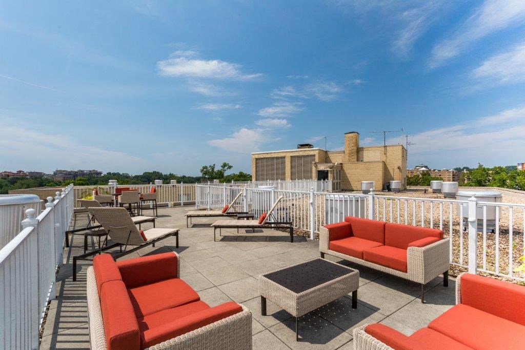 a rooftop patio with couches and tables on a roof