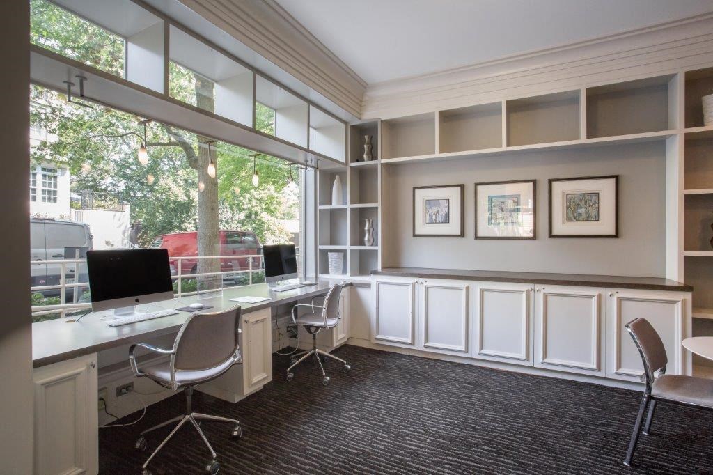 an office with a window and two desks with computers