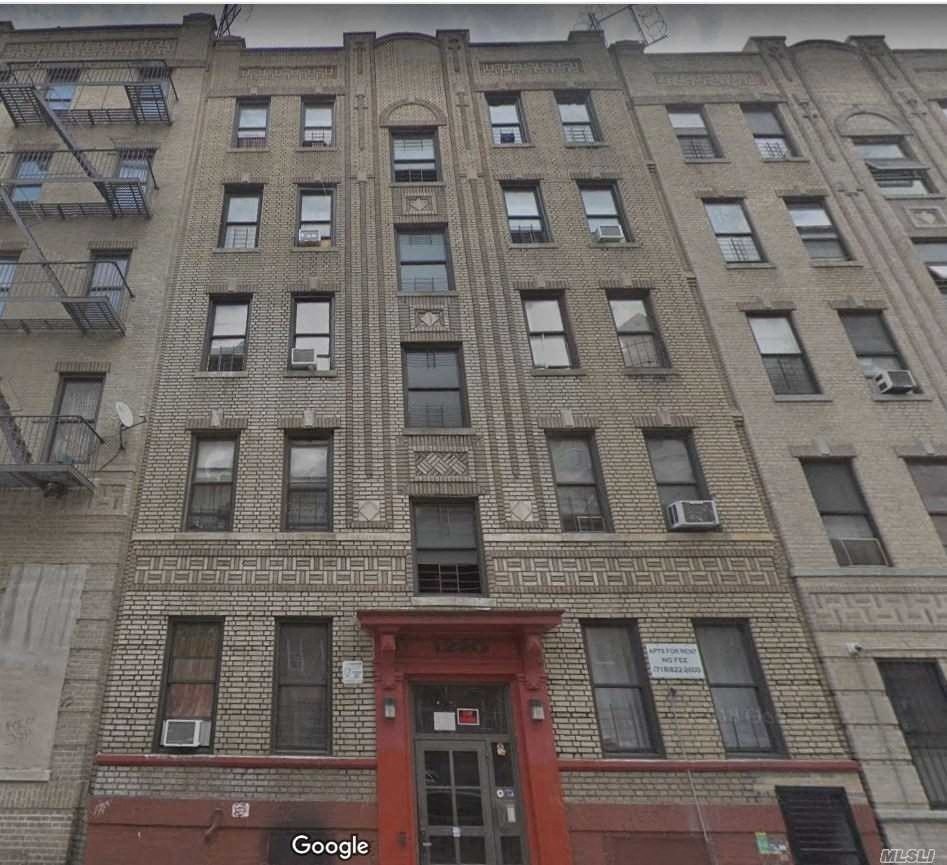 the front of a brick building with a red door