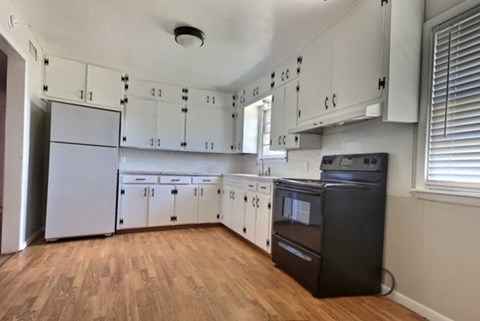 A kitchen with white cabinets and a black dishwasher.