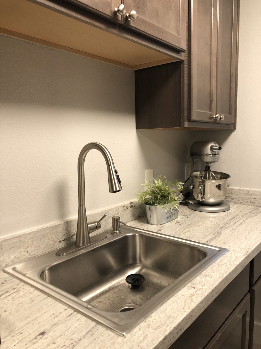 a kitchen sink with a chrome faucet in a granite counter top