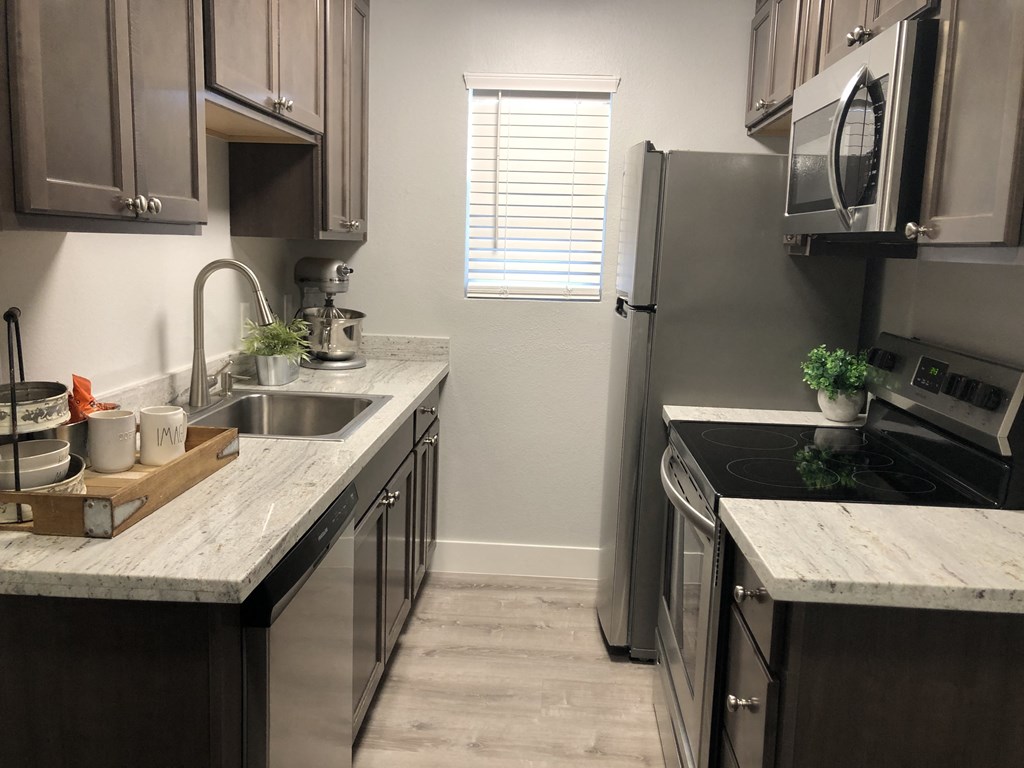 a kitchen with stainless steel appliances and marble counter tops