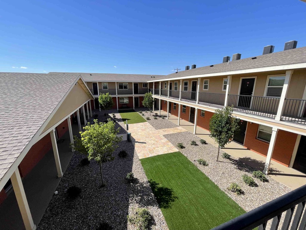 a view of the courtyard from the balcony of an apartment building