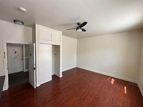 A room with a ceiling fan and a doorway leading to another room.
