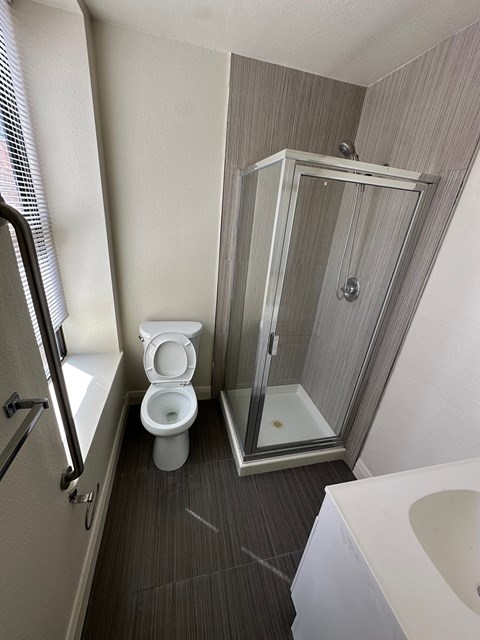 A white toilet sits in a bathroom next to a walk-in shower.