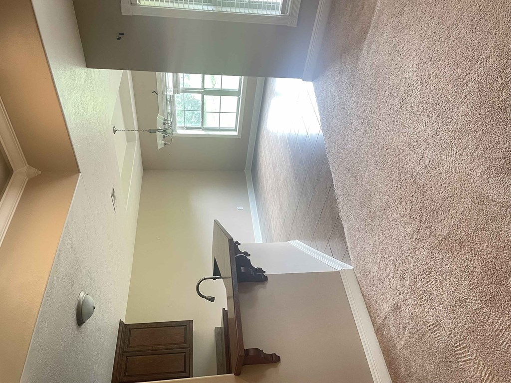 a view from the top of a staircase looking down into a room with a window
