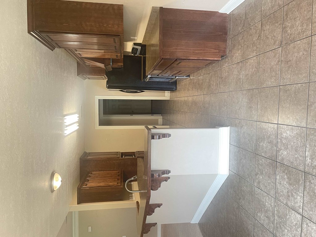 a small kitchen with a refrigerator and a staircase