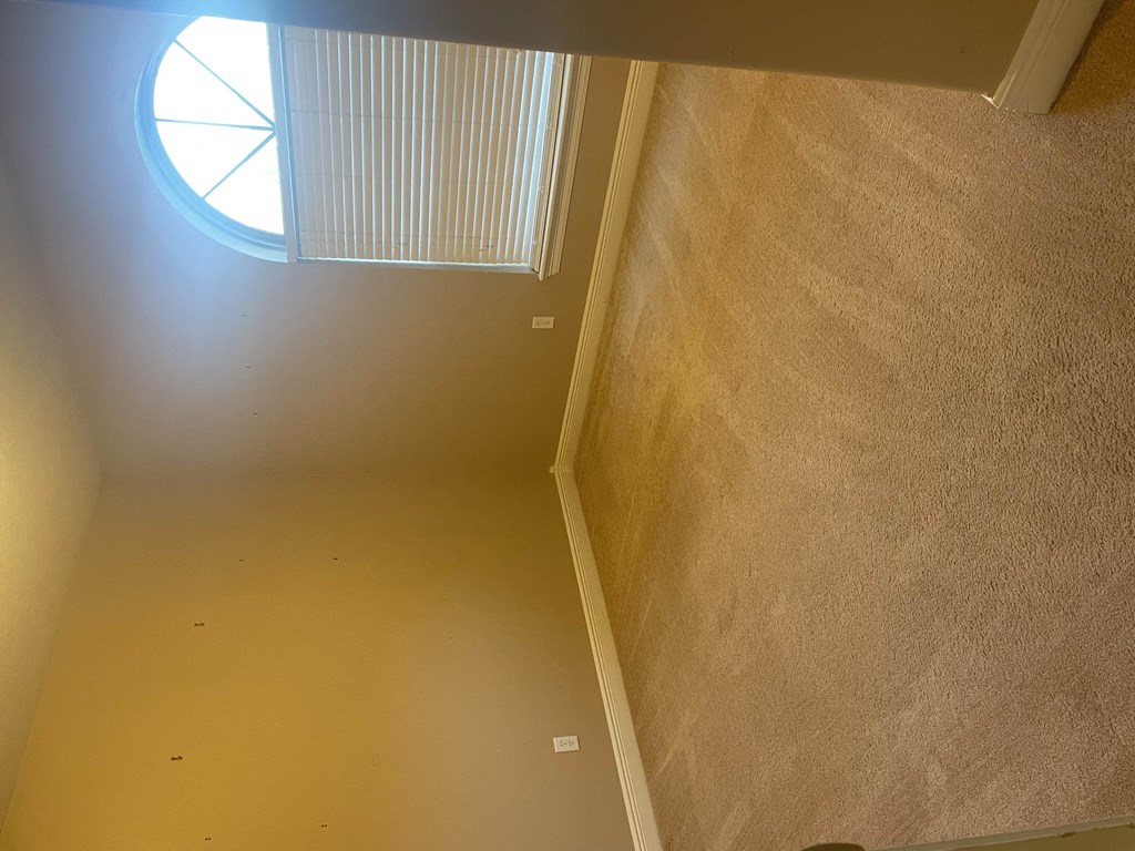 a room with a window and a stairwell and a carpeted floor