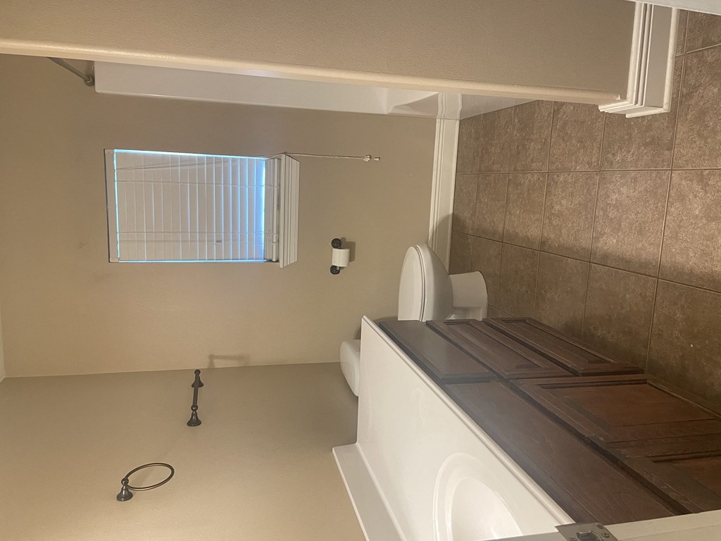 a bathroom with a toilet and a sink and a window