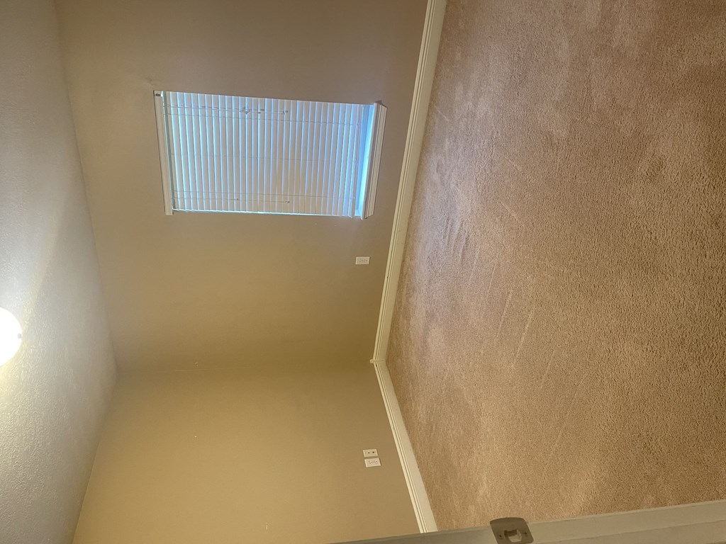 an empty room with a window on the wall