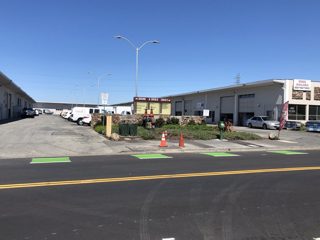 a parking lot in front of a building with traffic cones