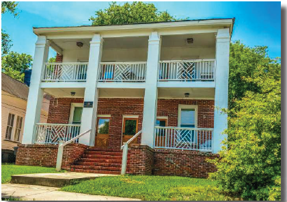 the front of a brick house with a porch