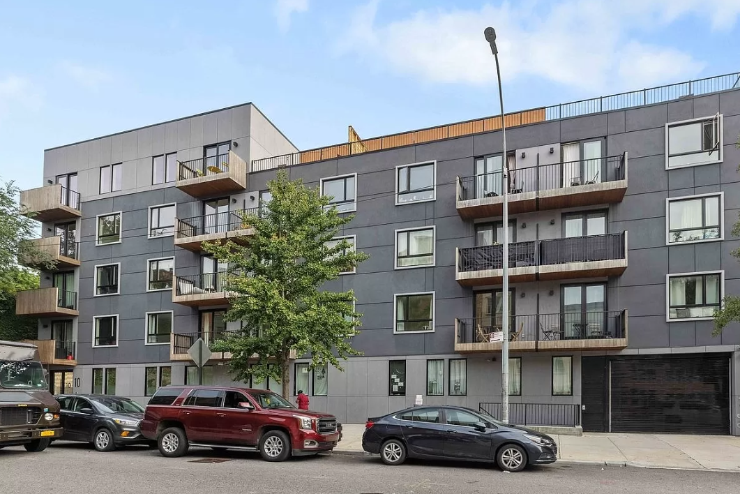 an apartment building with cars parked in front of it