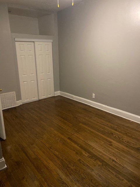 an empty room with wooden floors and two doors